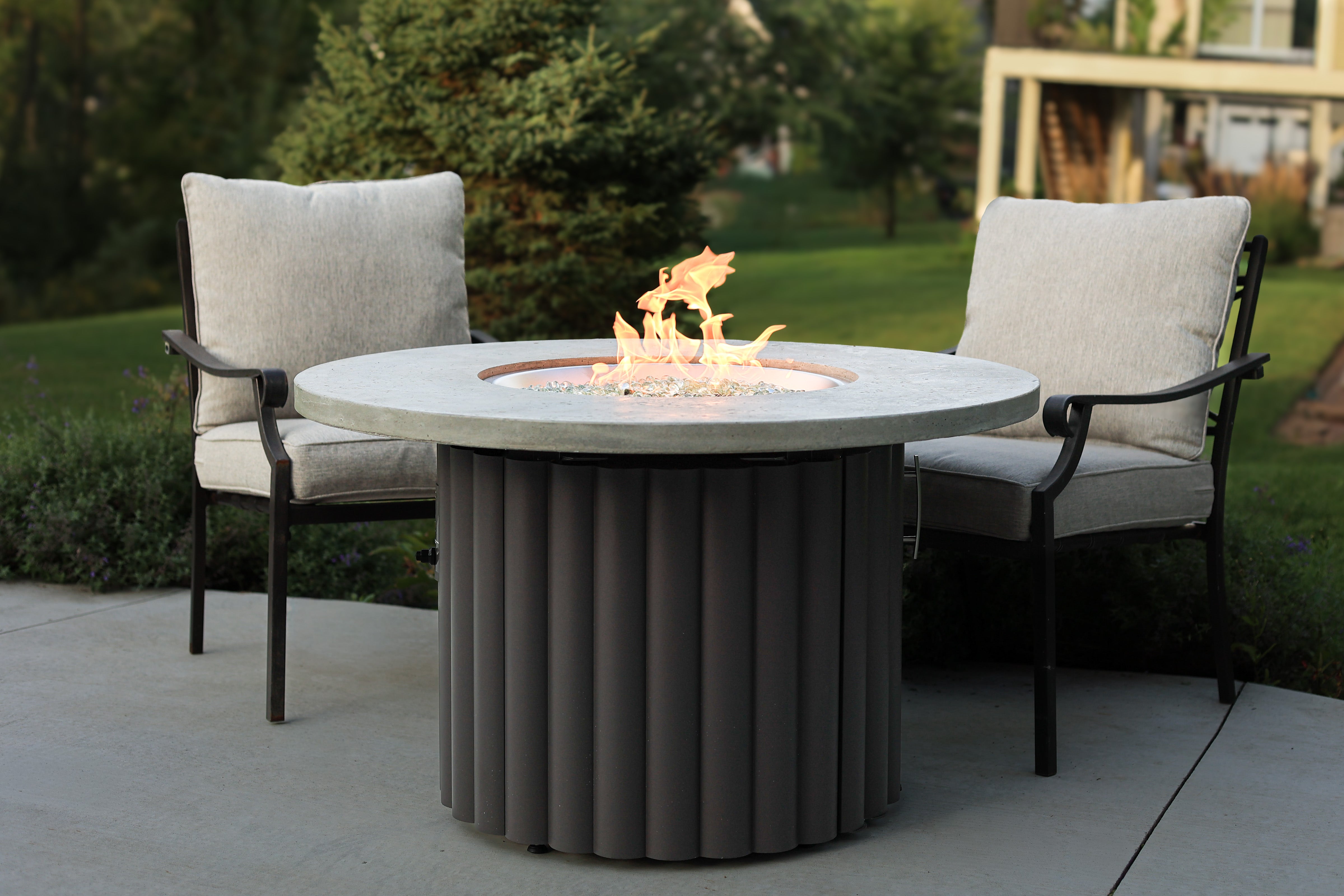 A 42" Reverie Gas Fire Table with Relic Grey Supercast Top and Charcoal Grey Scalloped Aluminum Base