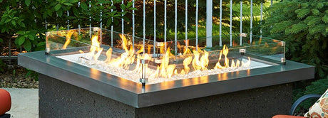 The Crystal Fire Plus L-Shaped Gas Burner being used on a fire pit table in a patio setting