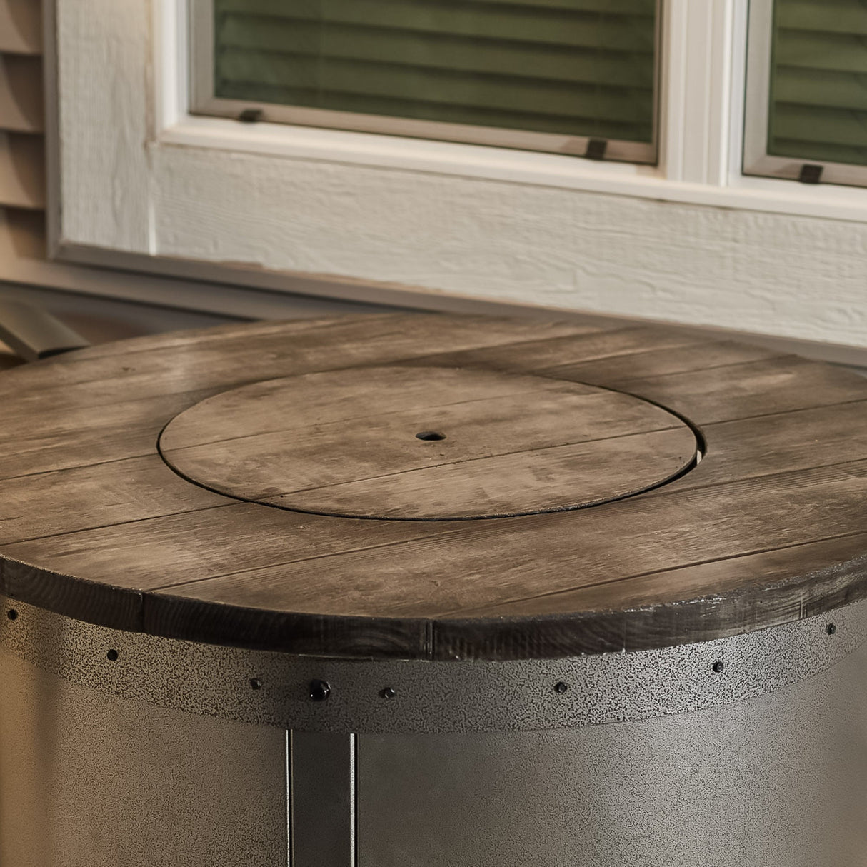 A close up view of the cover that goes on the burner of an Edison Round Gas Fire Pit Table