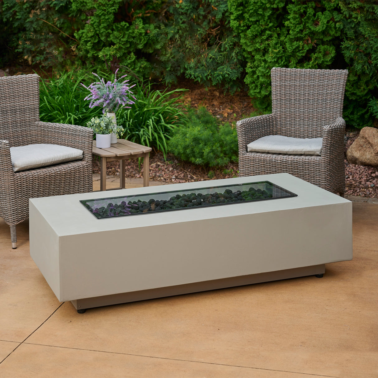 The Harbor View Rectangular Gas Fire Pit Table on a patio setting with a glass cover over the burner