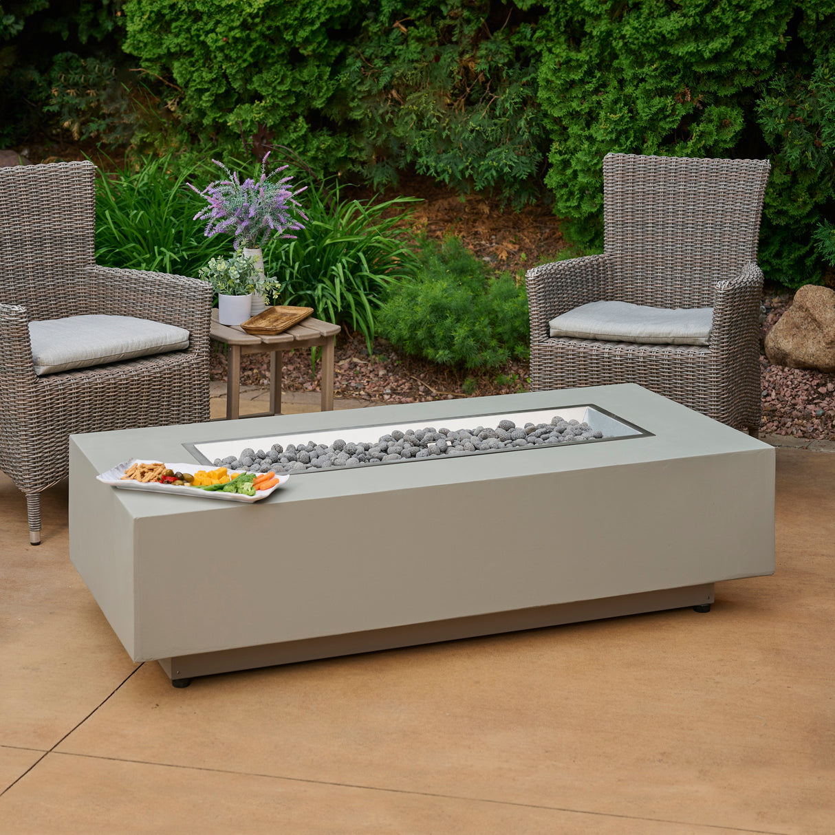 The Harbor View Rectangular Gas Fire Pit Table in a patio setting with food placed on the top of the table