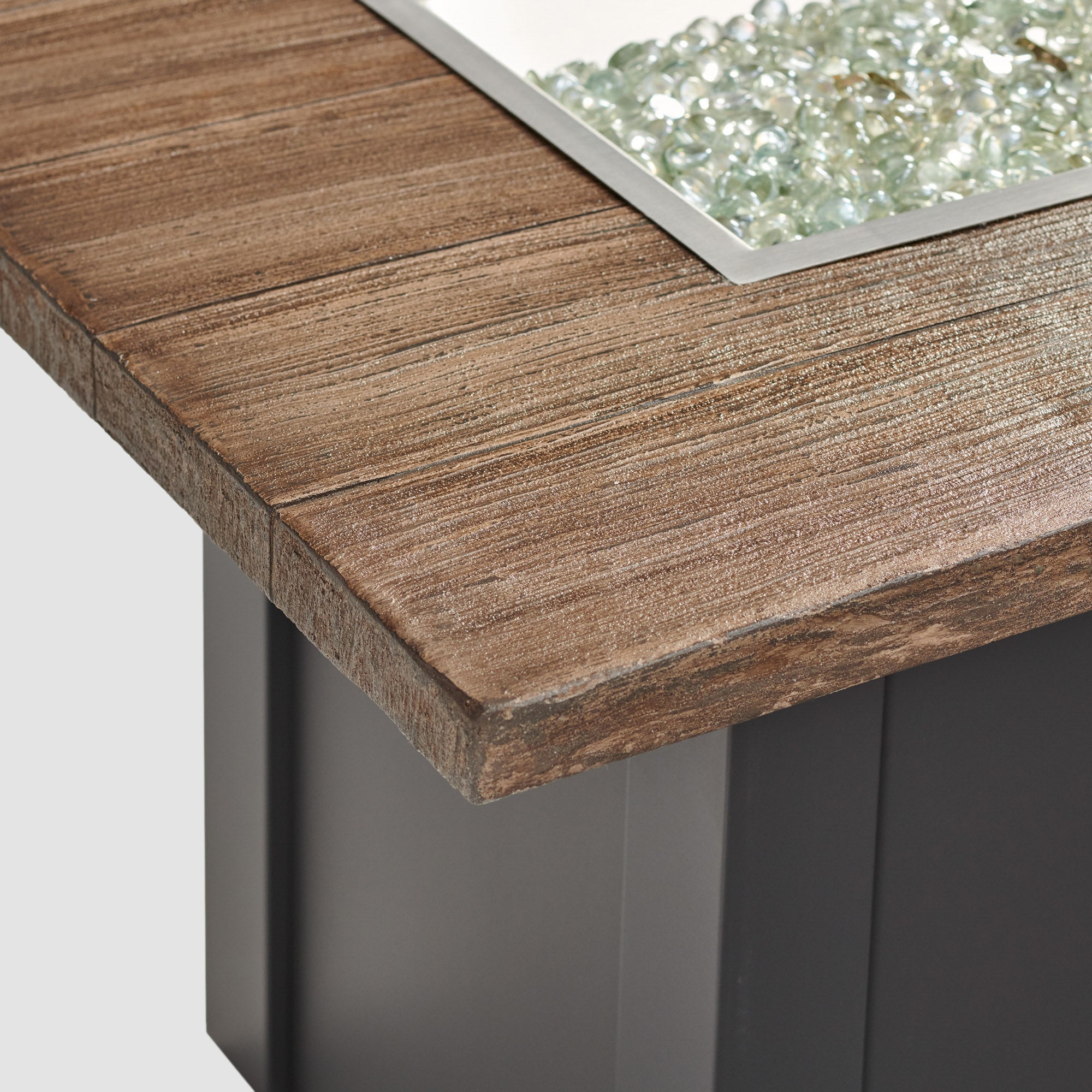A close up view of the detail found on the top of a Havenwood Linear Gas Fire Pit Table with a Driftwood top and Graphite Grey base