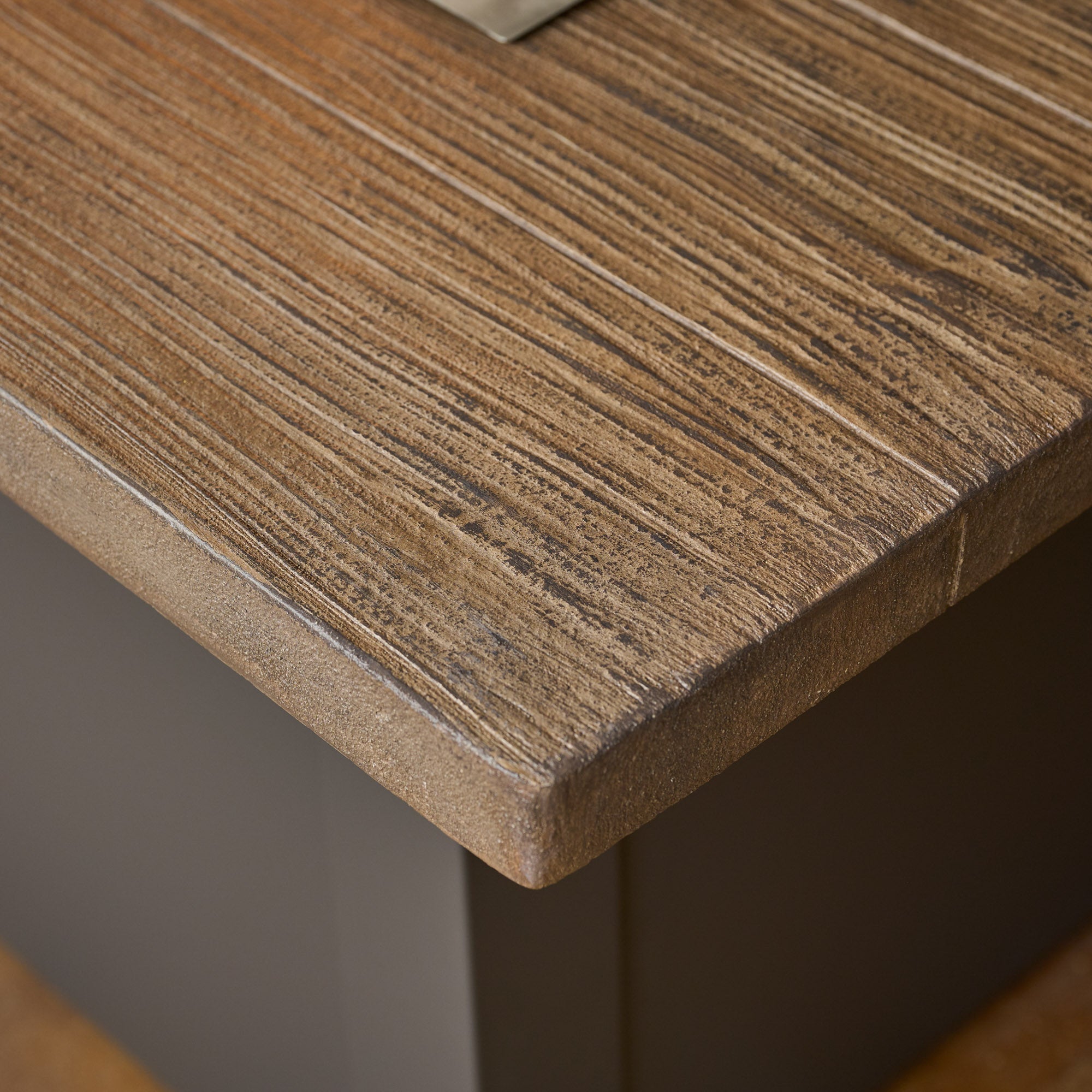 A close up view of the top of the Havenwood Linear Gas Fire Pit Table with a Driftwood top and Graphite Grey base
