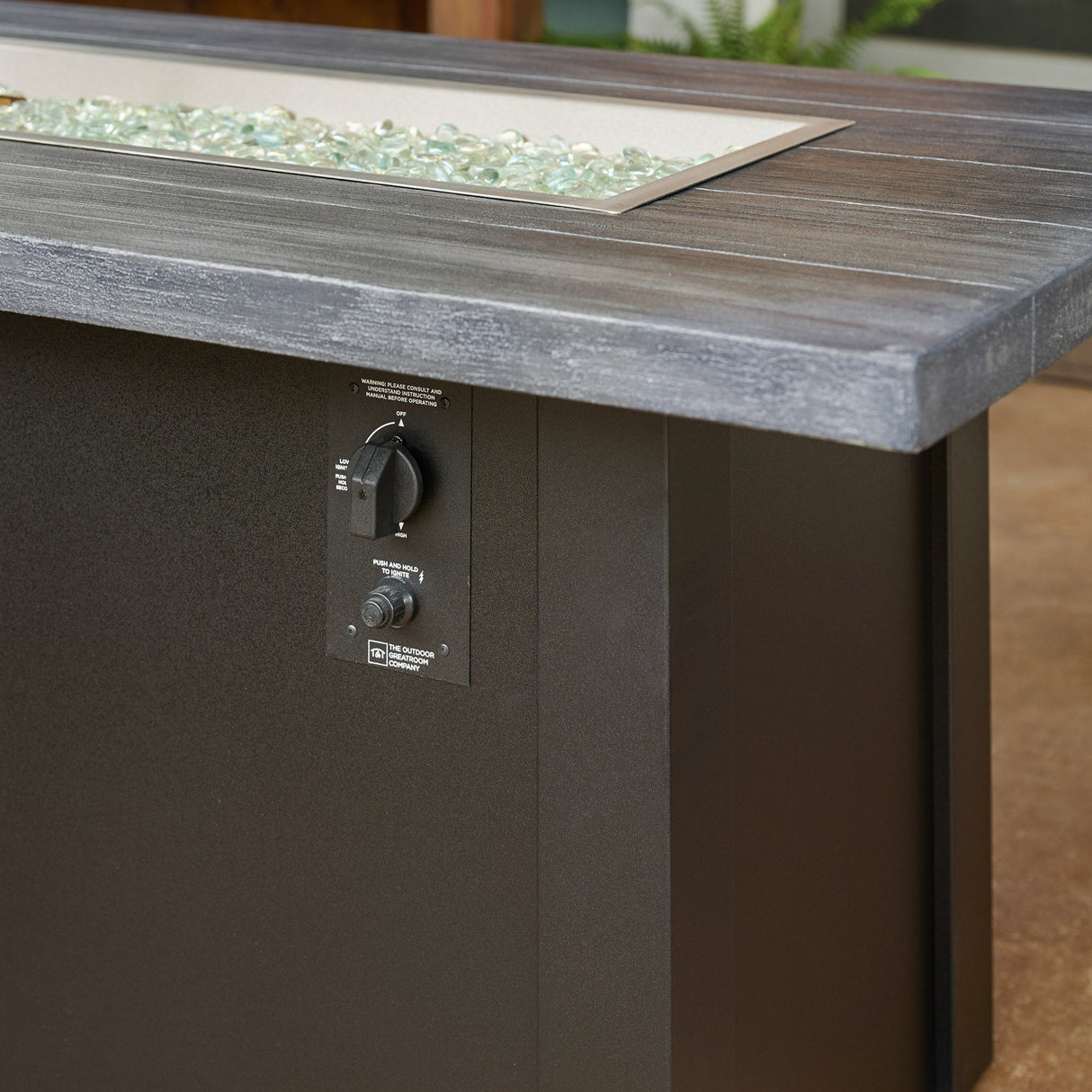 A close up view of the control panel used on a Havenwood Linear Gas Fire Pit Table with a Carbon Grey top and Luverne Black base