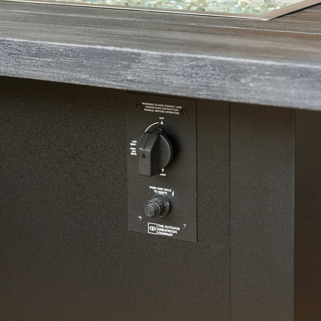 A detailed view of the control panel used on the Havenwood Linear Gas Fire Pit Table with a Carbon Grey top and Luverne Black base