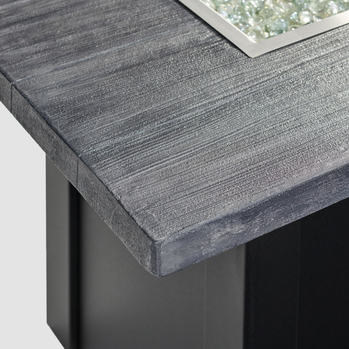 A close up view of the detail found on the top of a Havenwood Linear Gas Fire Pit Table with a Carbon Grey top and Luverne Black base
