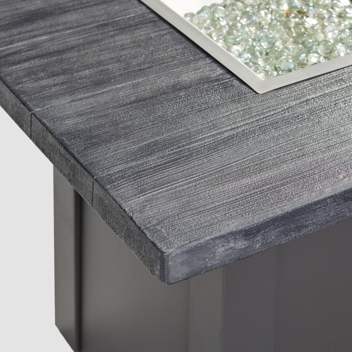 A close up view of the detail found on the top of a Havenwood Linear Gas Fire Pit Table with a Carbon Grey top and Graphite Grey base