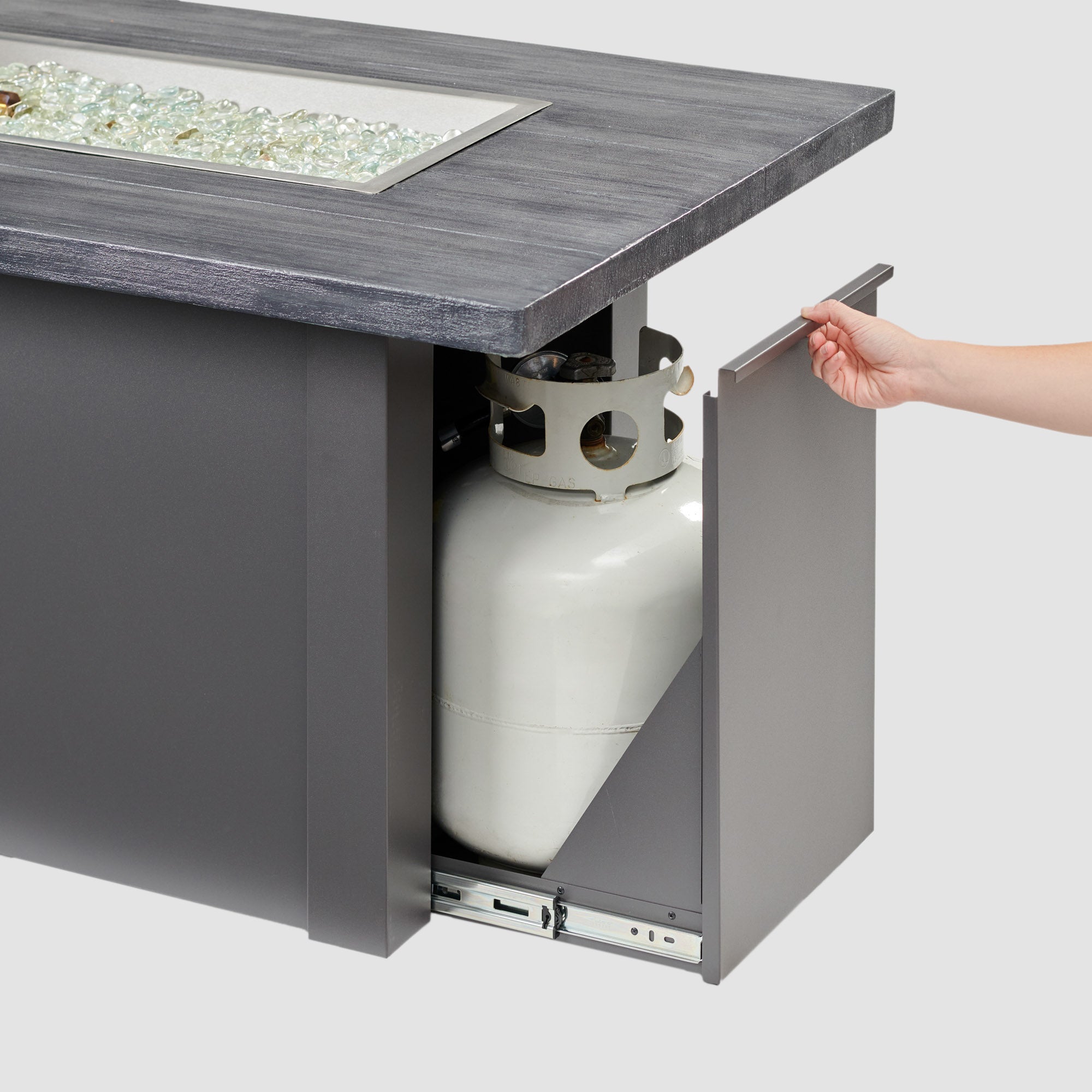 The side access door being opened on a Havenwood Linear Gas Fire Pit Table with a Carbon Grey top and Graphite Grey base