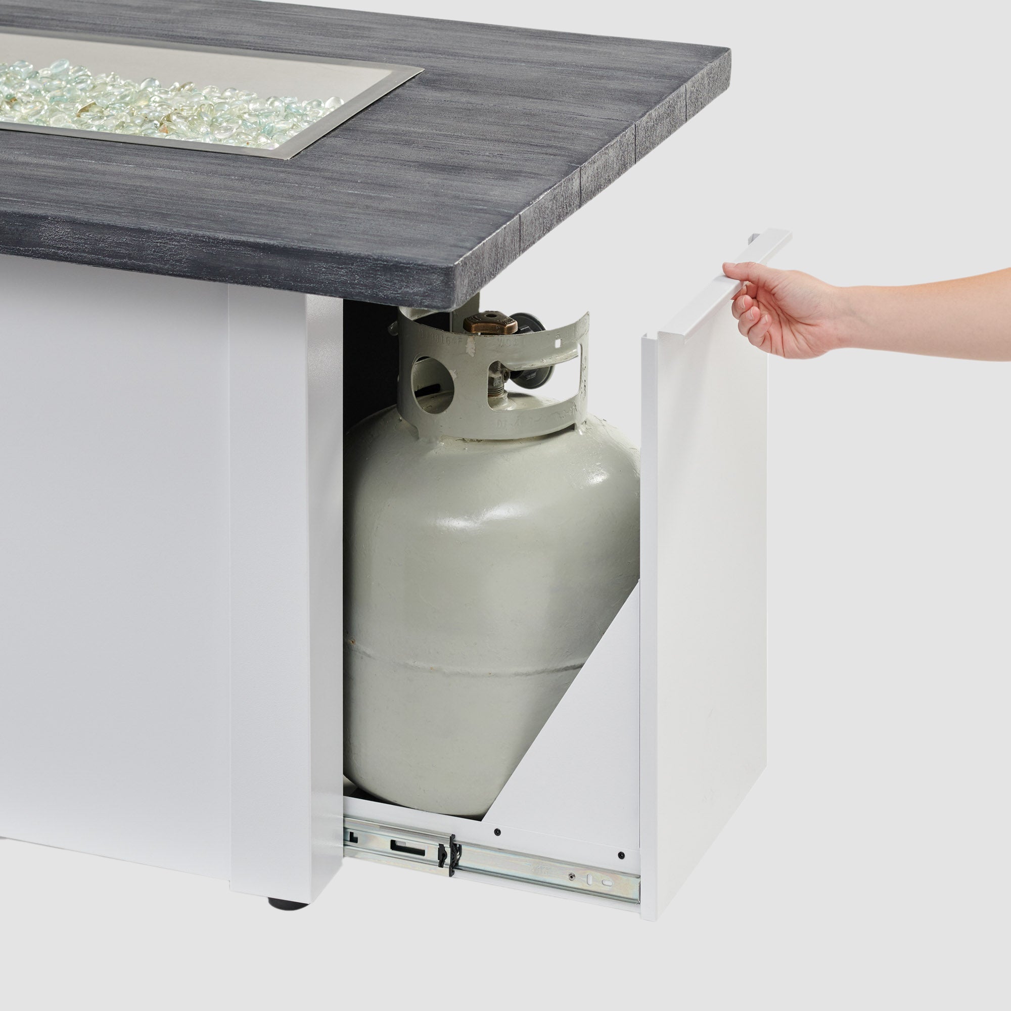 The side access door being opened on a Havenwood Linear Gas Fire Pit Table with a Carbon Grey top and White base