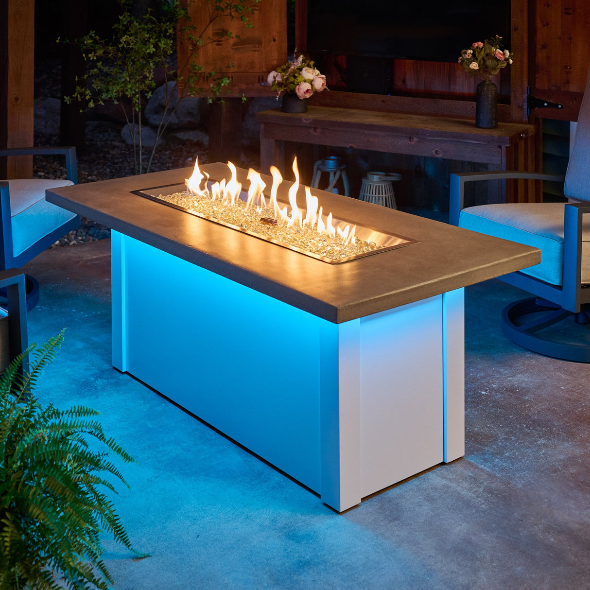 The Havenwood Linear Gas Fire Pit Table with a Pebble Grey top and White base with a large flame