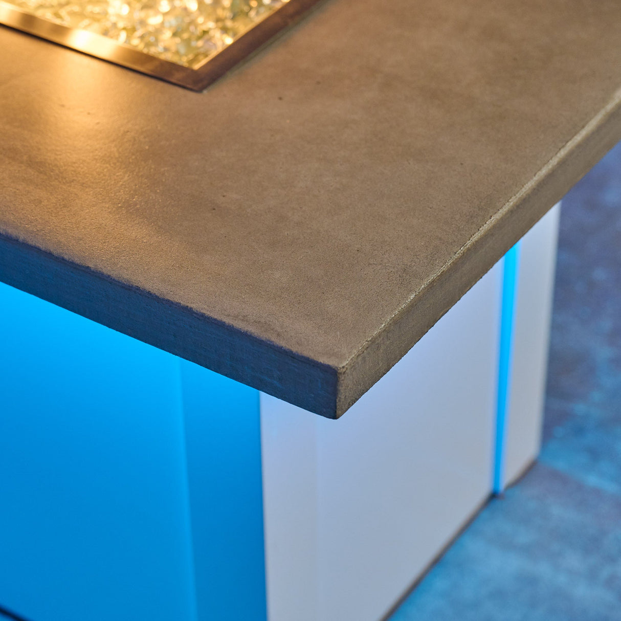 A view of the detail found on the top of a Havenwood Linear Gas Fire Pit Table with a Pebble Grey top and White base