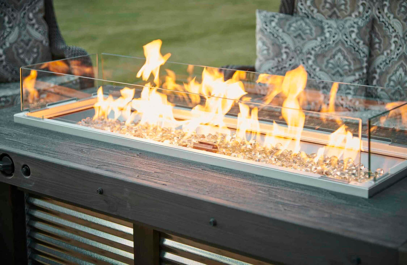 A close up view of the Denali Brew Linear Gas Fire Pit Table and a folding wind guard
