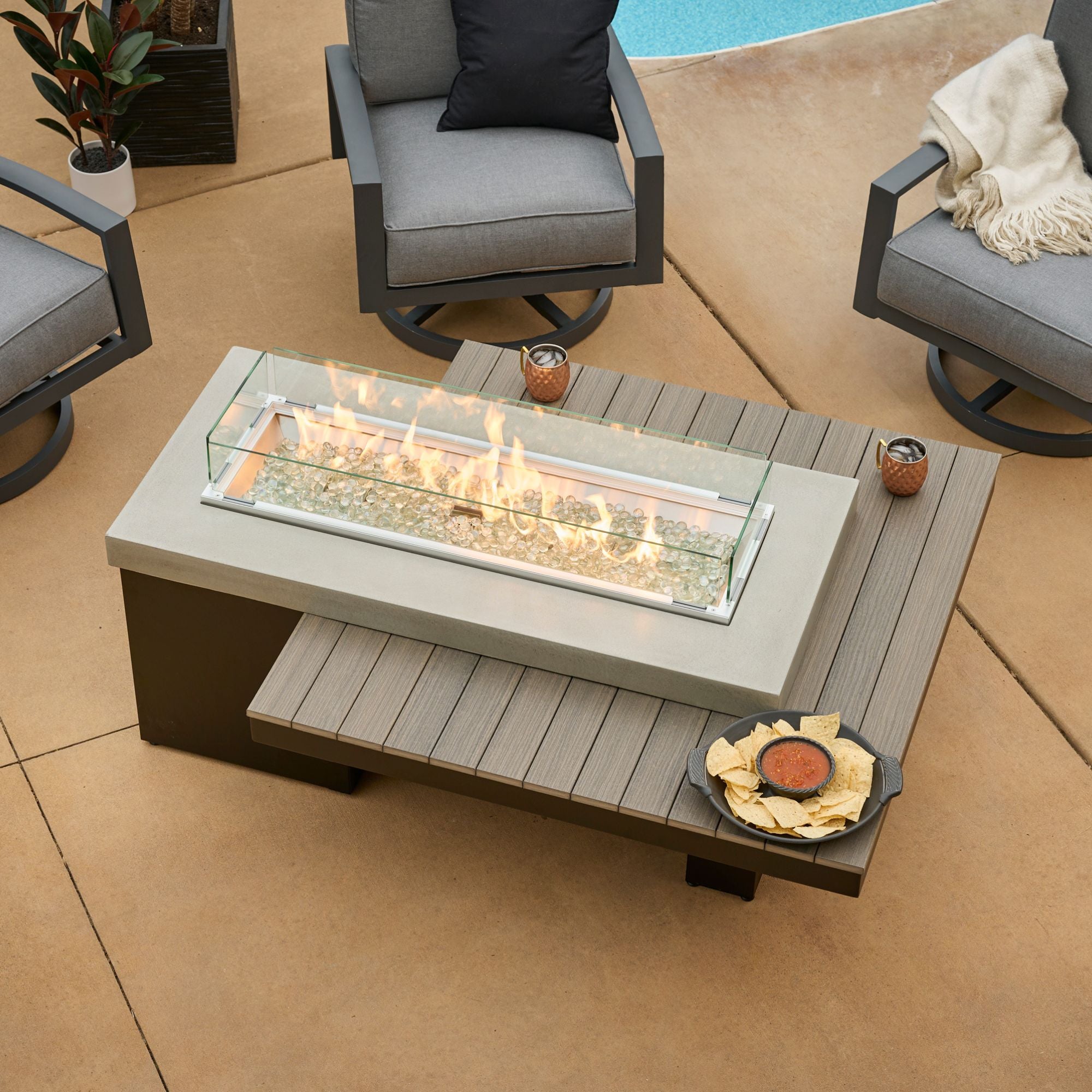 An aerial shot of the Uptown Coastal Grey Linear Gas Fire Pit Table on an outdoor patio