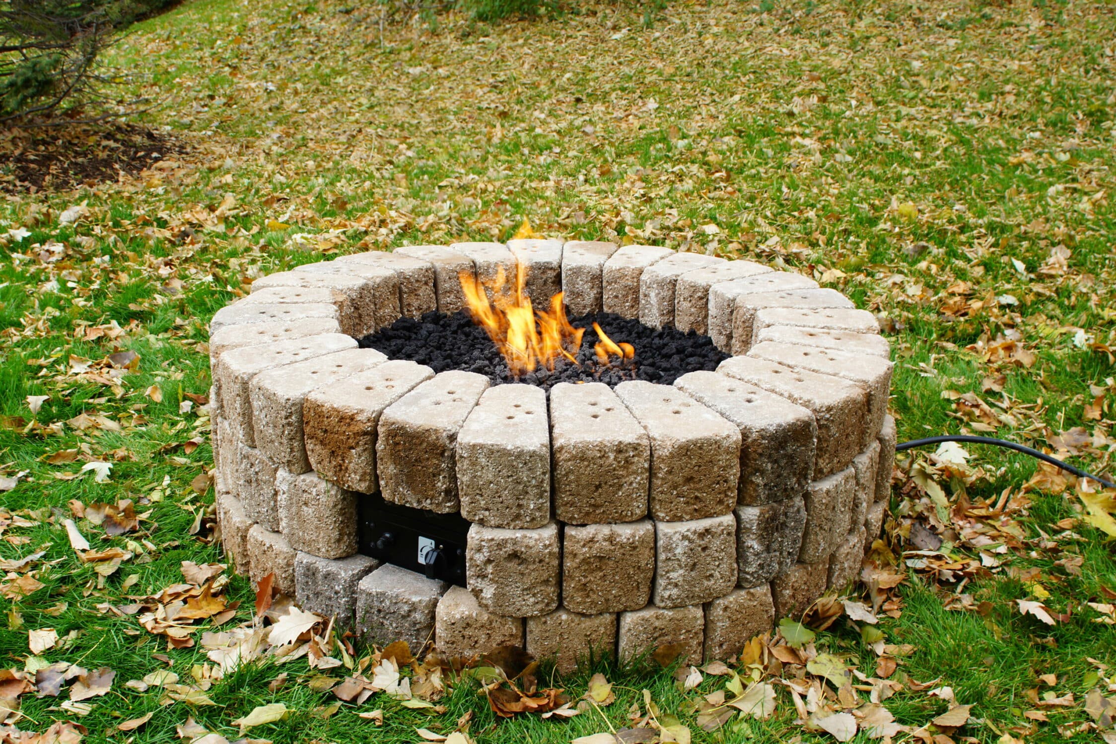 DIY patio with grass between pavers and a fire pit!