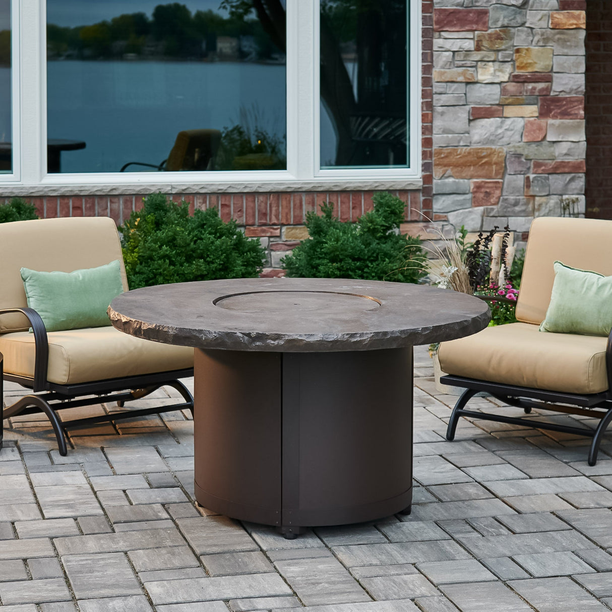 The Marbleized Noche Beacon Round Gas Fire Pit Table on a patio setting with its cover on