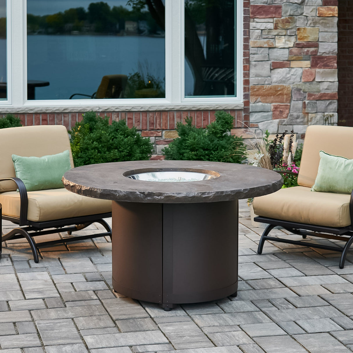 The Marbleized Noche Beacon Round Gas Fire Pit Table in an outdoor setting
