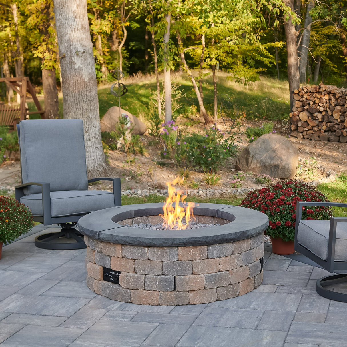 Charcoal Grey Concrete Top for Round Bronson Block Gas Fire Pit Kit with flame on a patio