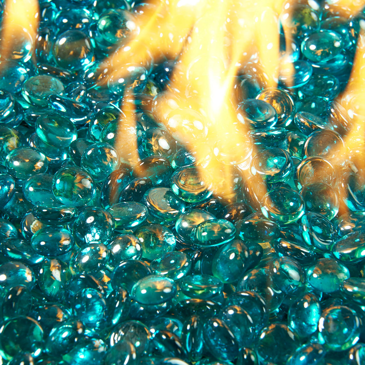 Close up of a flame coming through Aquamarine Tempered Fire Glass Gems for a Crystal Fire Burner