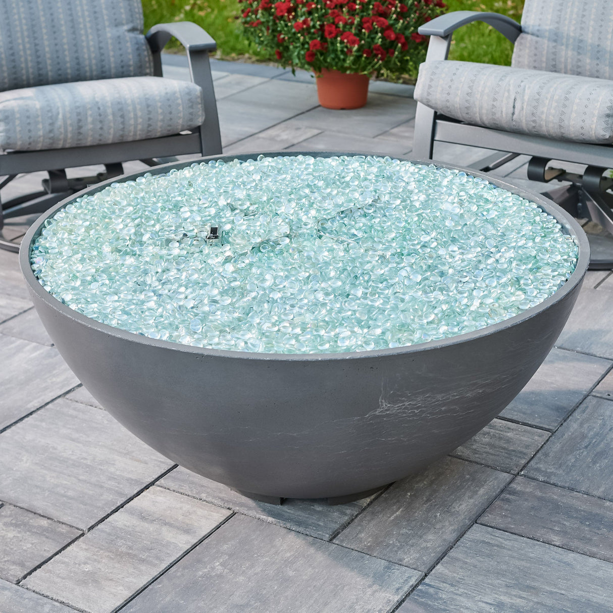 A view of fire gems on the burner of a Midnight Mist Cove Edge Round Gas Fire Pit Bowl 42"