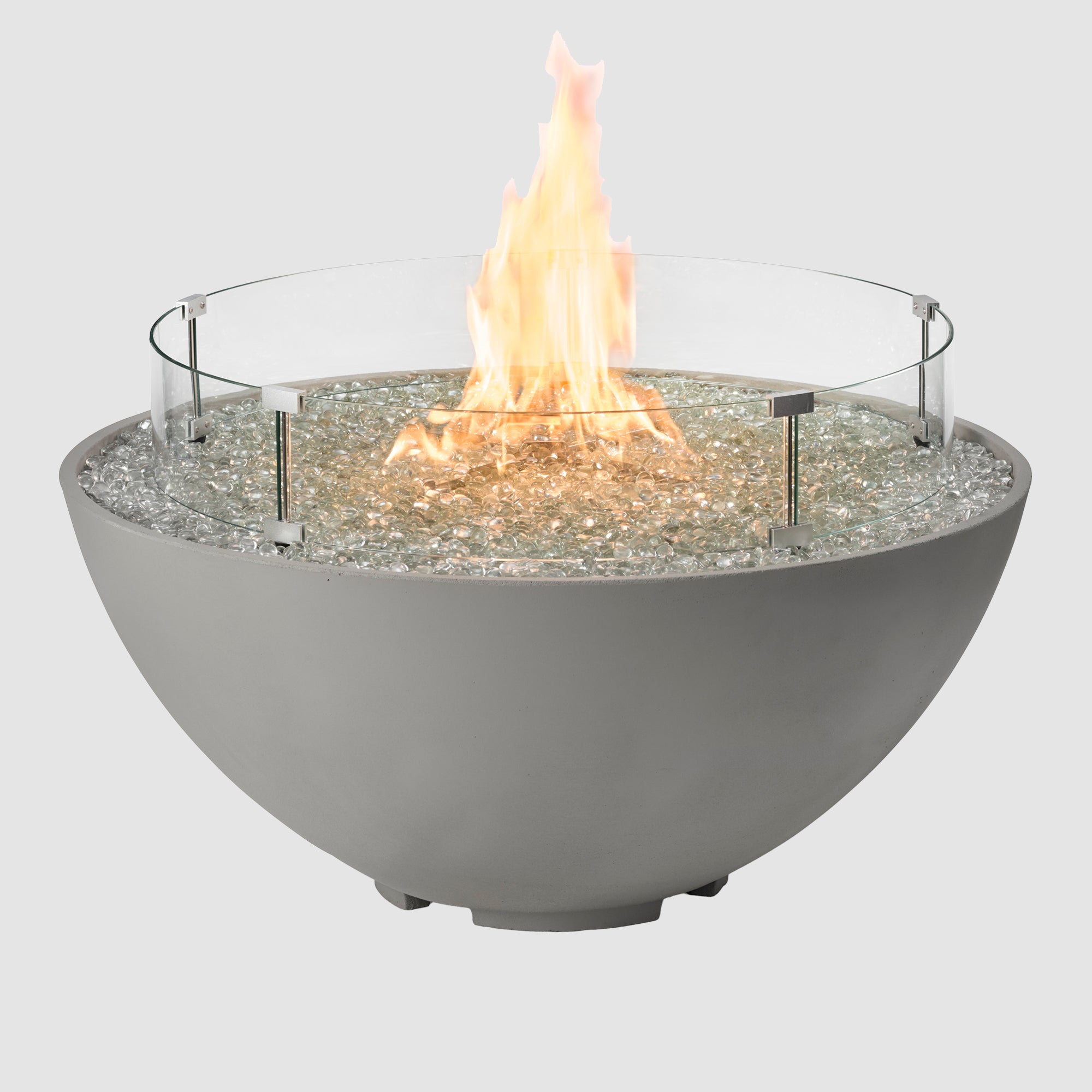 A glass wind guard placed on a Cove Edge Round Gas Fire Pit Bowl 42" on a grey background