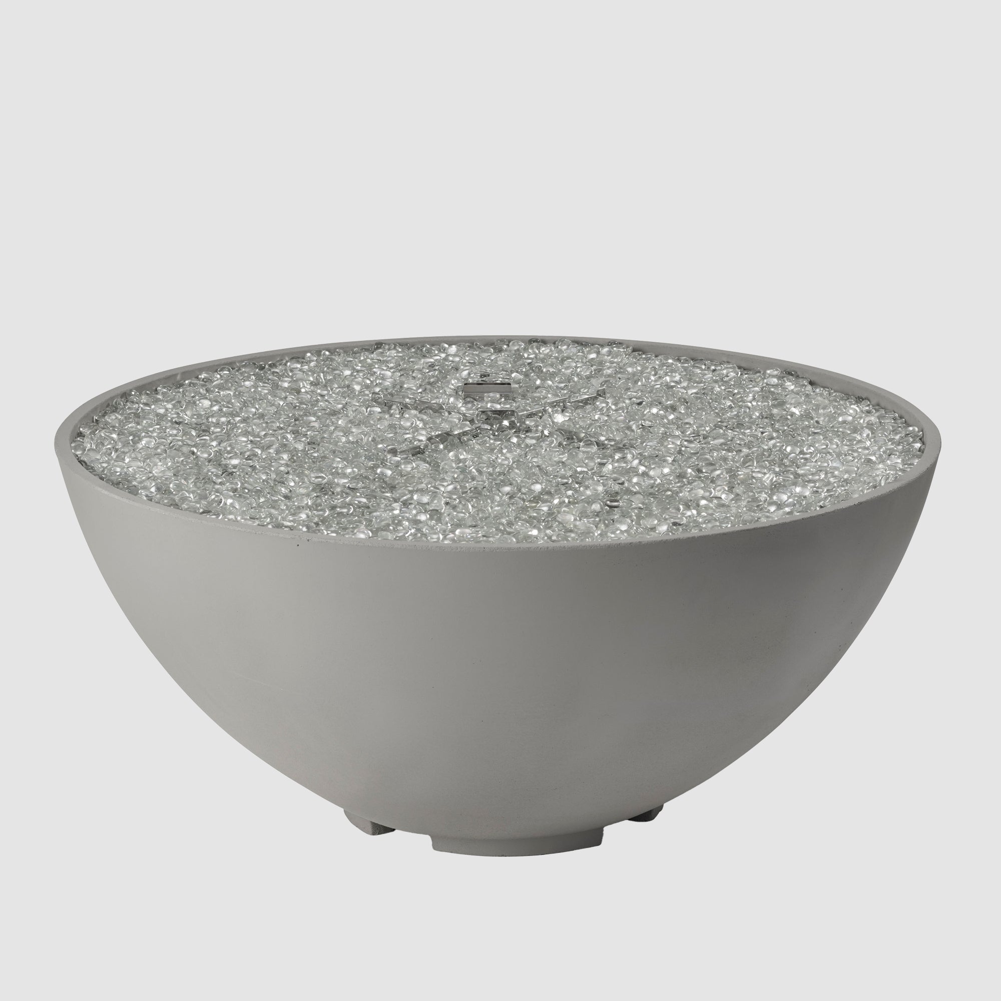 Fire gems on the burner of a Cove Edge Round Gas Fire Pit Bowl 42" on a grey background