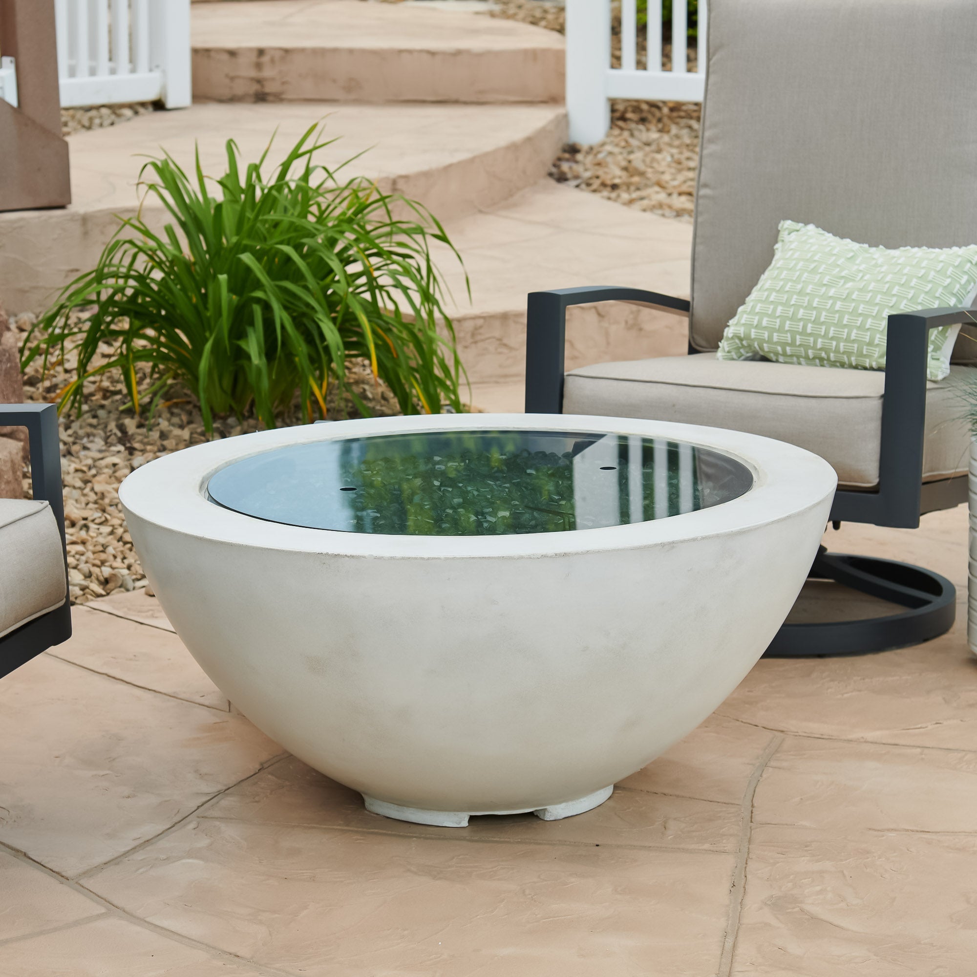 A cover placed on the burner of a White Cove Round Gas Fire Pit Bowl 42" while it is placed outside