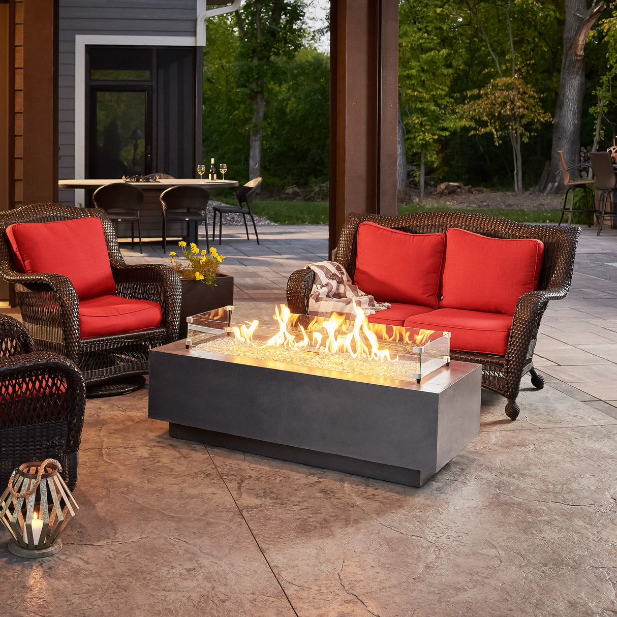 A glass wind guard placed on top of the Midnight Mist Cove Linear Gas Fire Pit Table 54"