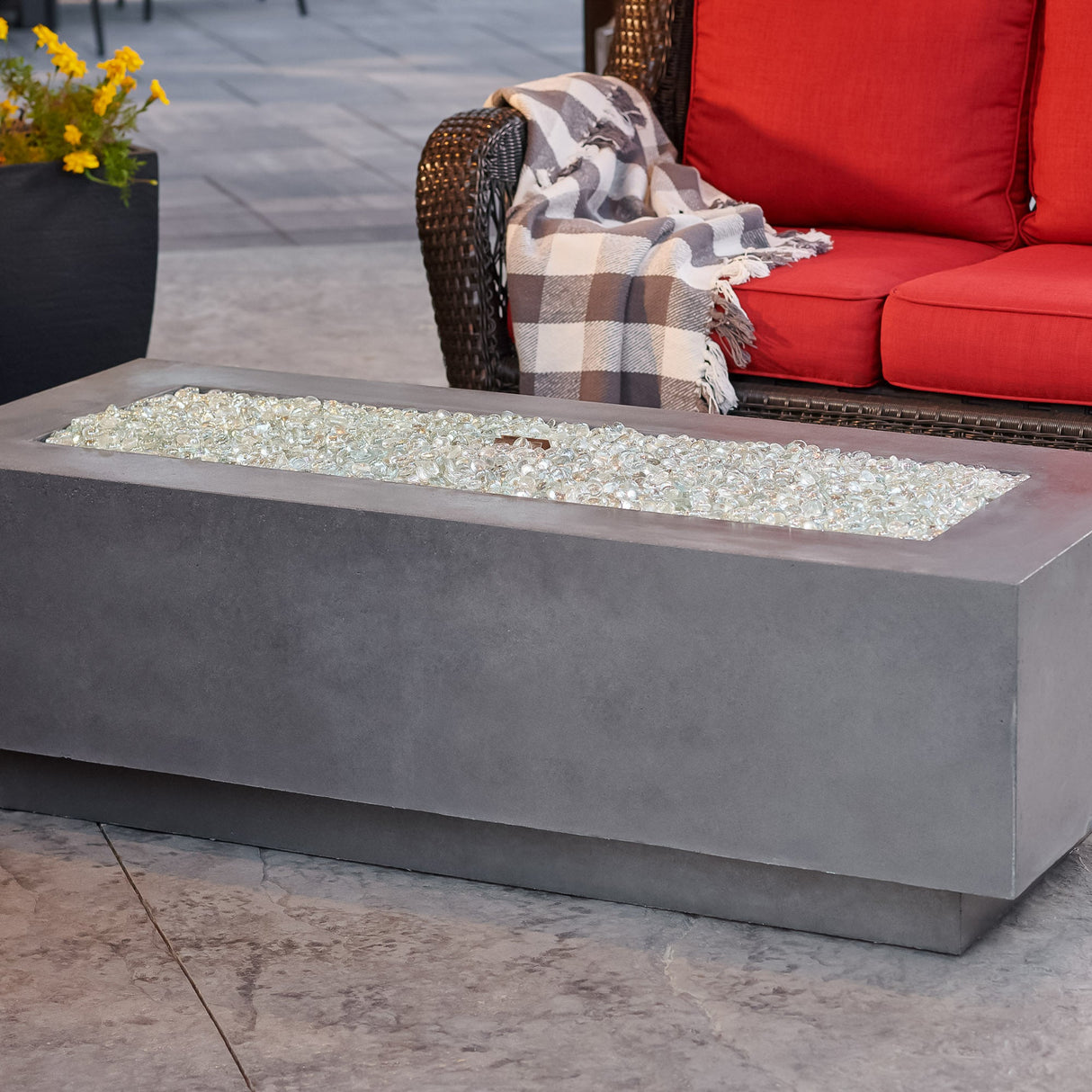 A close up of fire gems on the burner of a Midnight Mist Cove Linear Gas Fire Pit Table 54"