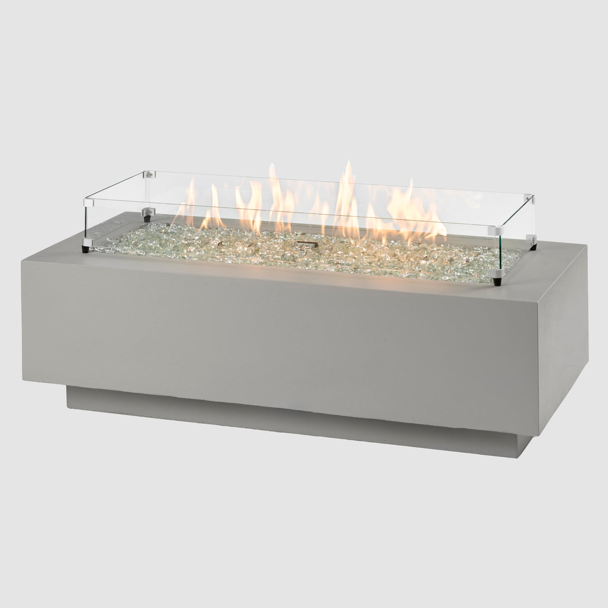 A glass wind guard placed on a Cove Linear Gas Fire Pit Table 54" on a grey background