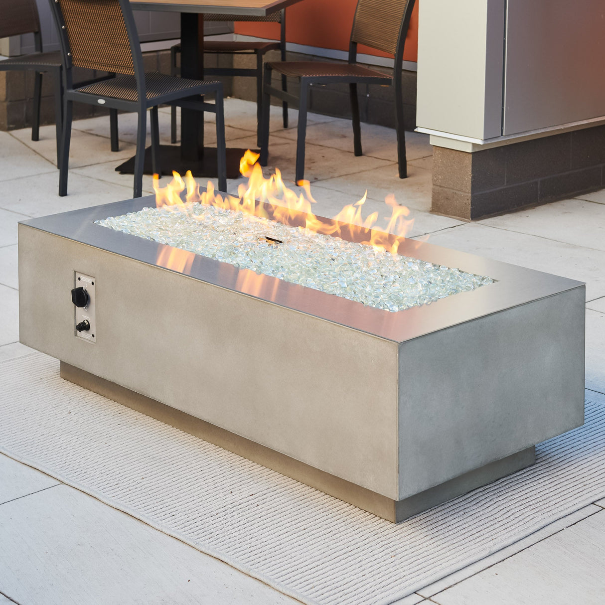 A Stainless Steel overlay placed on top of the Natural Grey Cove Linear Gas Fire Pit Table 54"