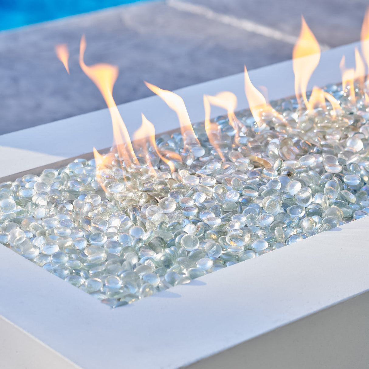 A close up view of the flames that come through the fire gems on a White Cove Linear Gas Fire Pit Table 72"