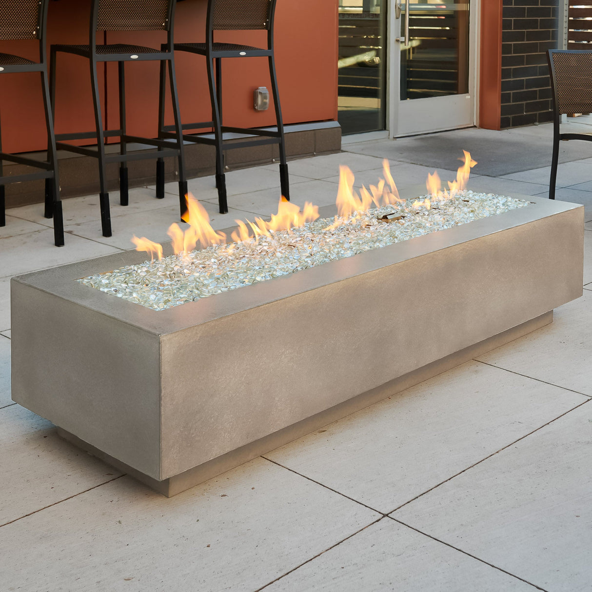 A Natural Grey Cove Linear Gas Fire Pit Table 72" in a commercial space