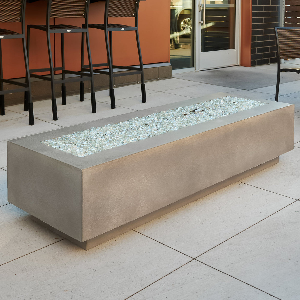 Fire media placed on the burner of a Natural Grey Cove Linear Gas Fire Pit Table 72"
