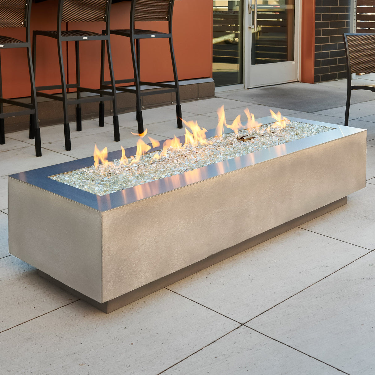 A Stainless Steel overlay placed on a Natural Grey Cove Linear Gas Fire Pit Table 72"