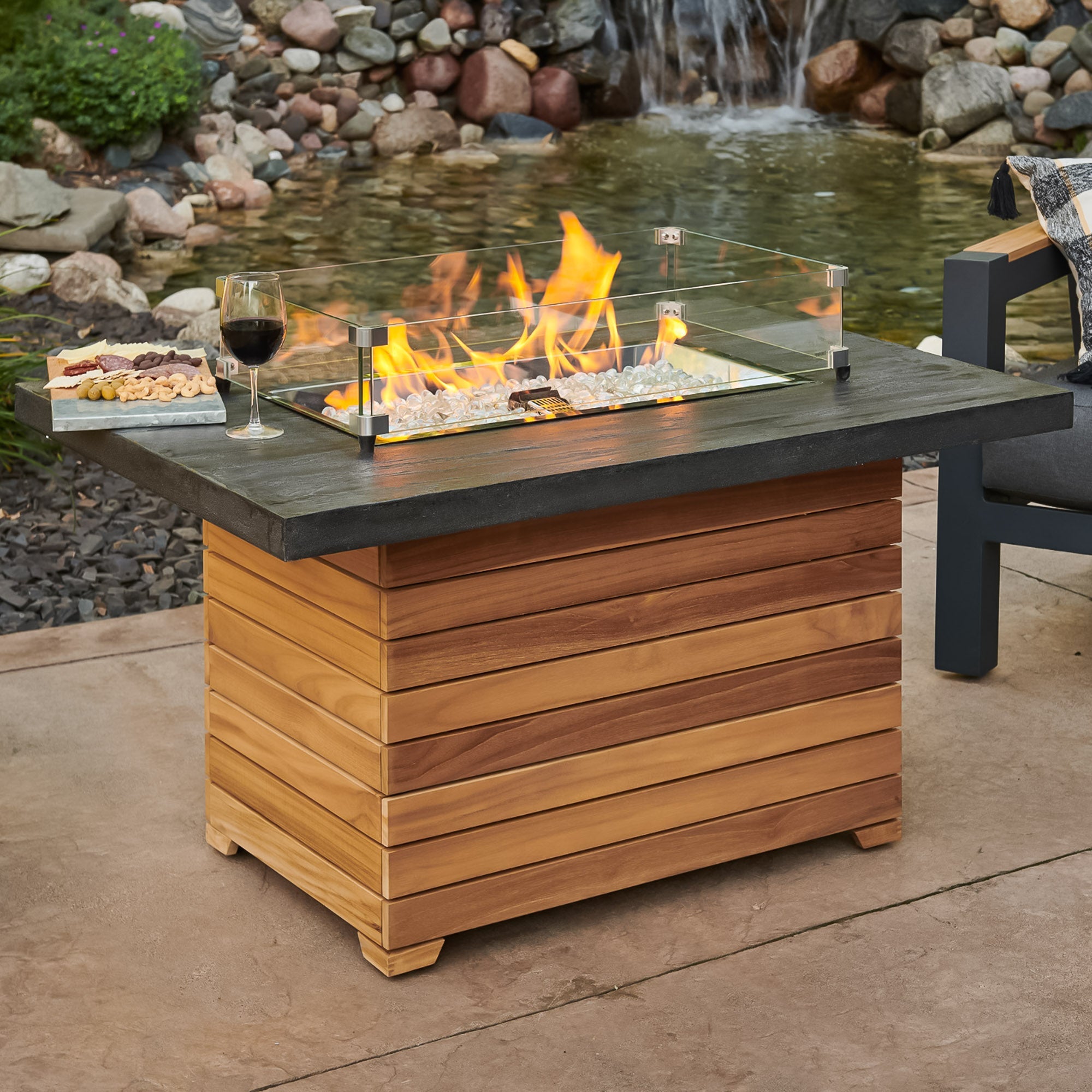 The Darien Rectangular Gas Fire Pit Table with an Everblend top being used as a table with food and drink