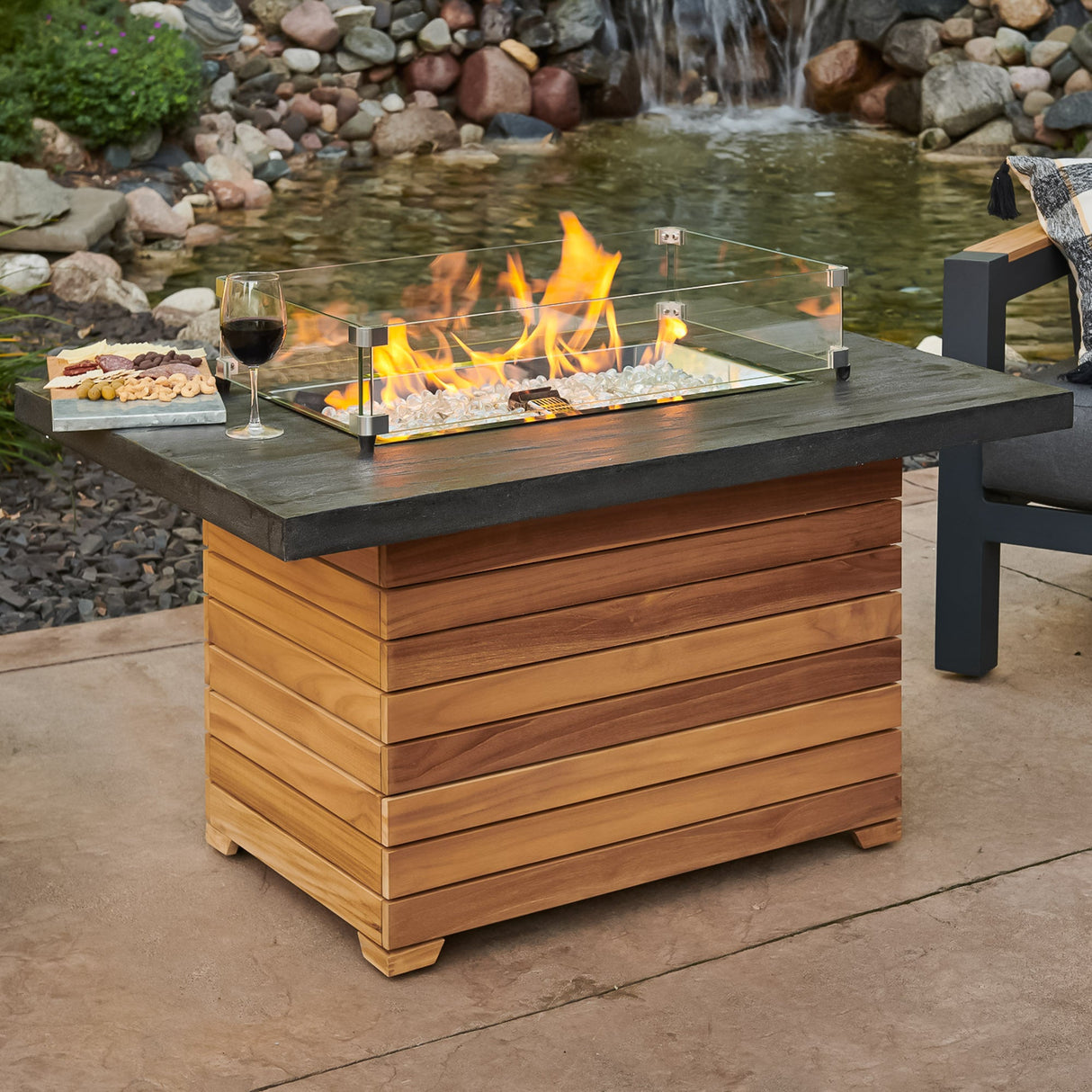 The Darien Rectangular Gas Fire Pit Table with an Everblend top being used as a table with food and drink