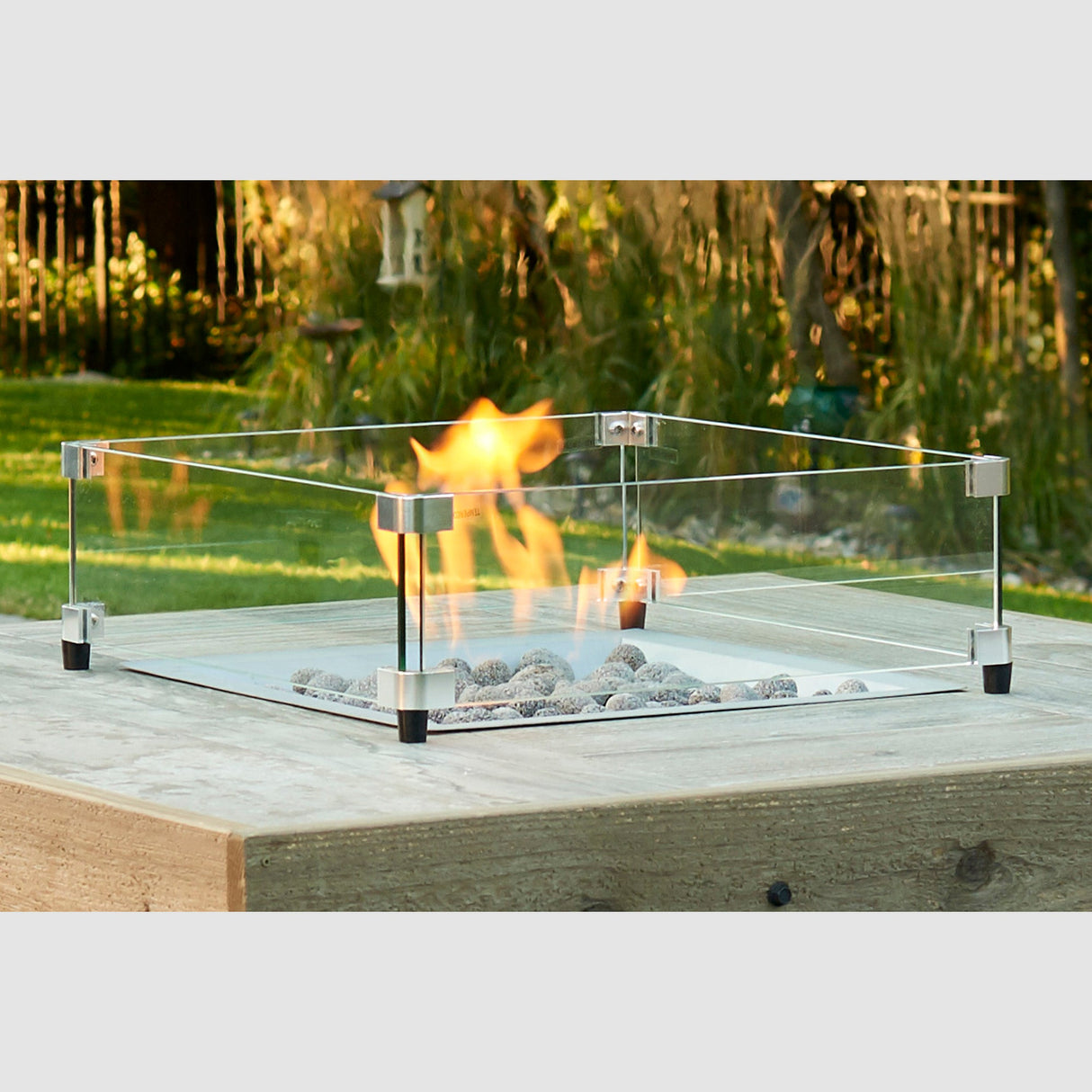 The Square Glass Wind Guard being used in a background setting to protect the flame coming from the burner