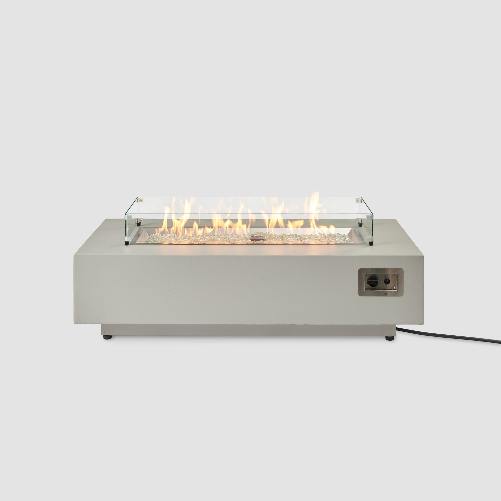 A front view of the Harbor View Rectangular Gas Fire Pit Table with a glass wind guard on the burner