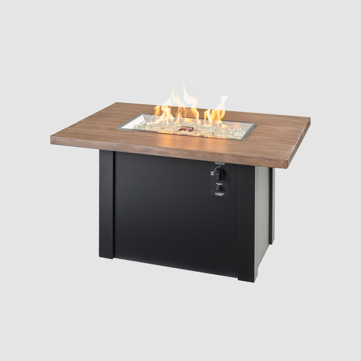 A large flame coming off the burner of a Havenwood Rectangular Gas Fire Pit Table with a Driftwood top and Luverne Black base