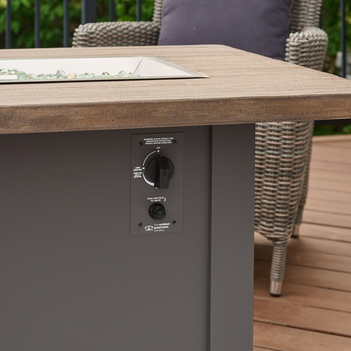A side view of the control panel on the Havenwood Rectangular Gas Fire Pit Table with a Driftwood top and Graphite Grey base