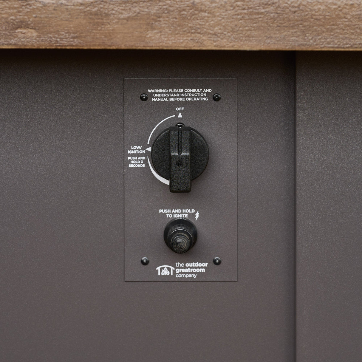 A detailed view of the control panel used on a Havenwood Linear Gas Fire Pit Table with a Driftwood top and Graphite Grey base