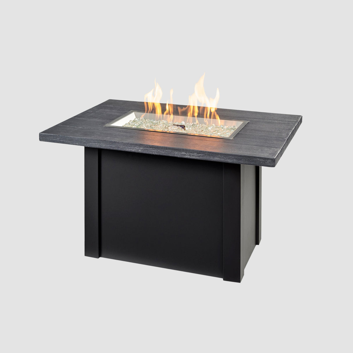 A large flame coming off the burner of a Havenwood Rectangular Gas Fire Pit Table with a Carbon Grey top and Luverne Black base