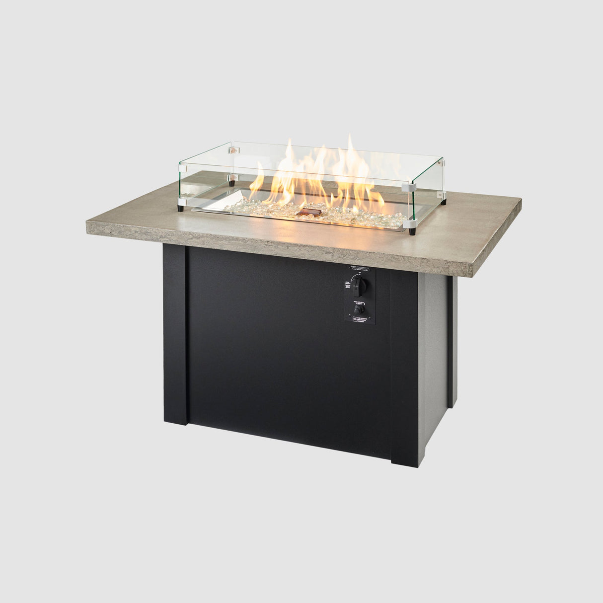 A glass wind guard placed on top of Havenwood Rectangular Gas Fire Pit Table with a Pebble Grey top and Luverne Black base