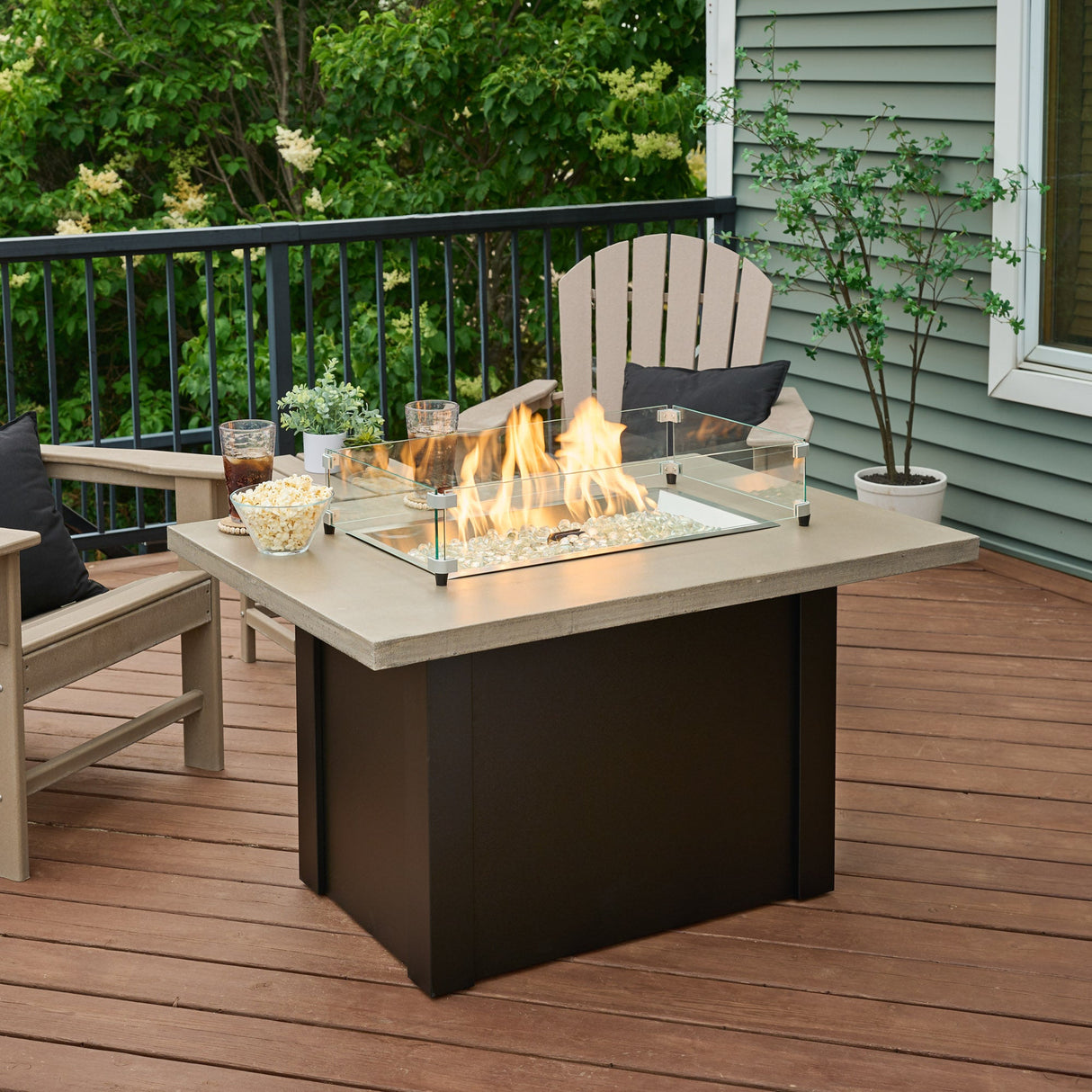 The Havenwood Rectangular Gas Fire Pit Table being used as a table with food and rink on the edges