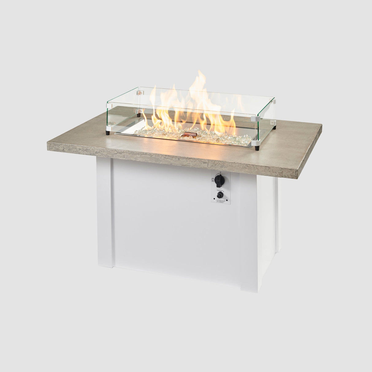 A glass wind guard used on the burner of a Havenwood Rectangular Gas Fire Table with a Pebble Grey top and White base