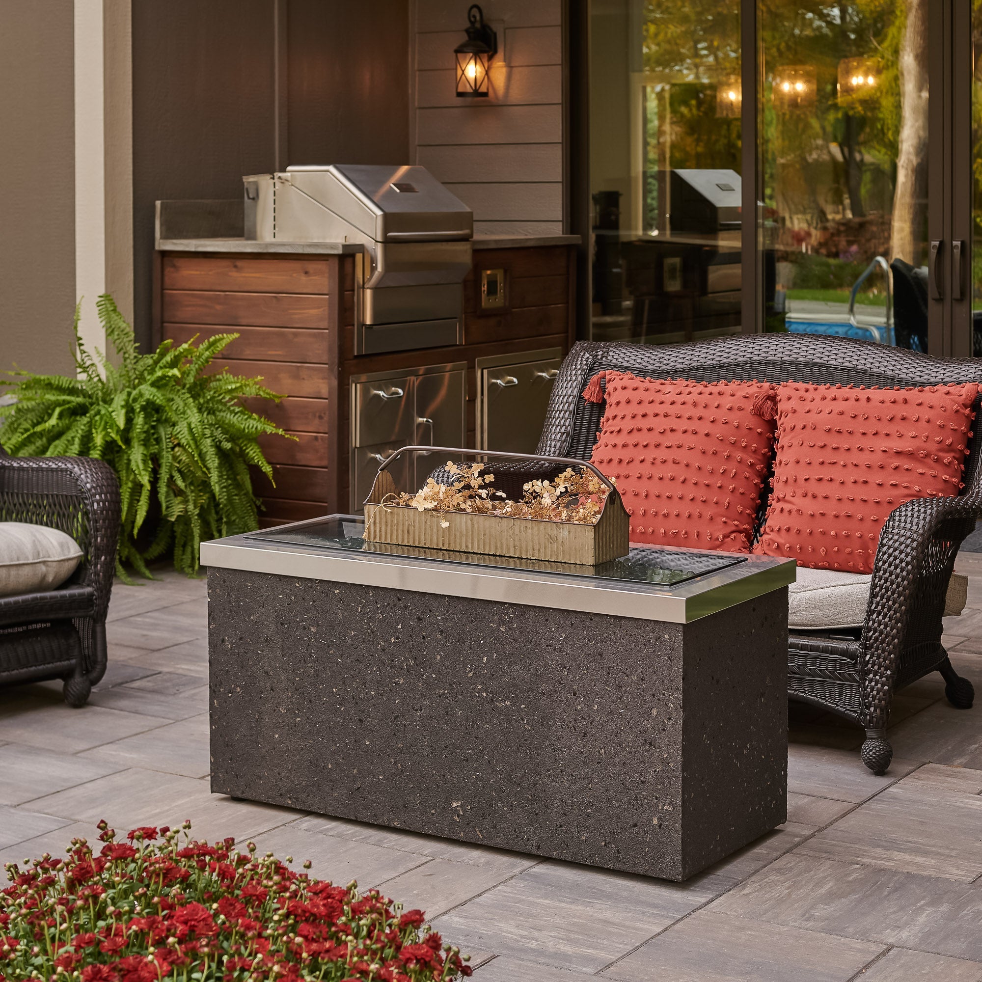 The Stainless Steel Key Largo Linear Gas Fire Pit Table being used as a table with its cover over the burner