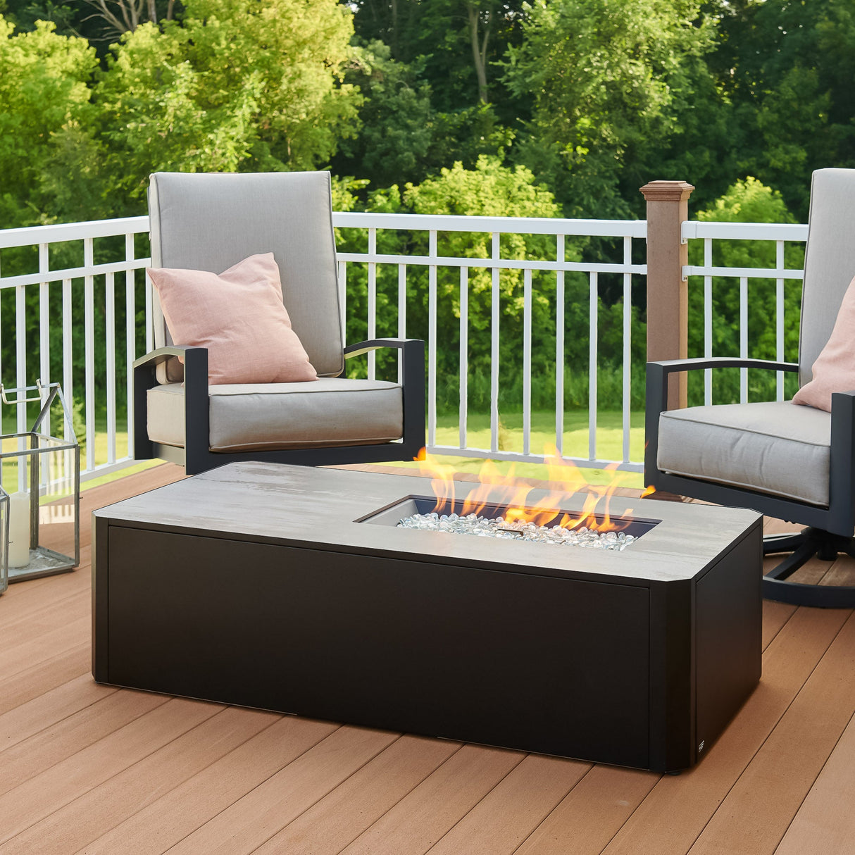 Kinney Rectangular Gas Fire Pit Table with a large flame coming from the burner in a patio setting