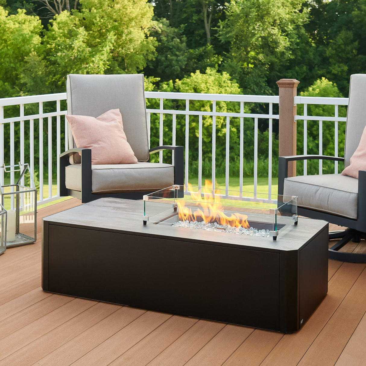 Kinney Rectangular Gas Fire Pit Table with a glass wind guard being used to protect the flame