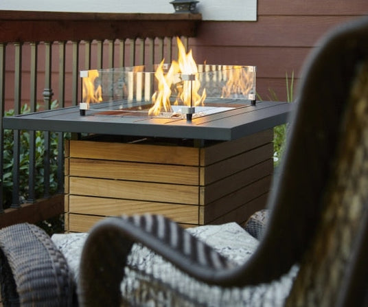 A Darien Rectangular Gas Fire Pit Table with an Aluminum top being used on an outdoor patio
