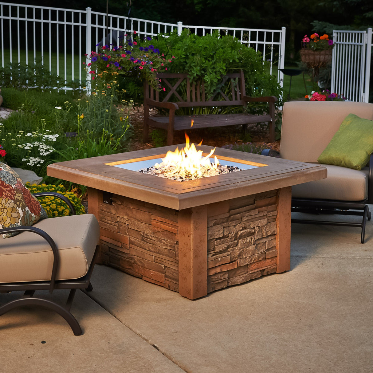 The Sierra Square Gas Fire Pit Table outside on a patio surrounded by outdoor furniture